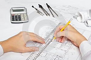 Architect working on blueprint. Architects workplace - architectural project, blueprints, ruler, calculator, laptop and