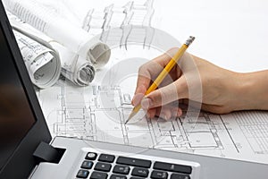Architect working on blueprint. Architects workplace - architectural project, blueprints, ruler, calculator, laptop and
