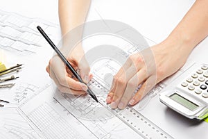 Architect working on blueprint. Architects workplace - architectural project, blueprints, ruler, calculator, laptop and