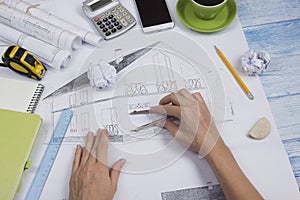 Architect working on blueprint. Architects workplace - architectural project, blueprints, ruler, calculator, laptop and