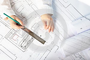 Architect working on blueprint. Architects workplace - architectural project, blueprints, ruler. Engineering tools. Top view
