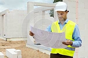 Architect working with blueprints at construction site. project control and supervision