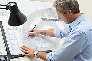 Architect Working At Drawing Table