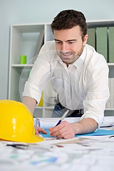 Architect working on his projects papers in the office