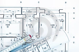 Architect workplace with project plans, rolled blueprints and ru