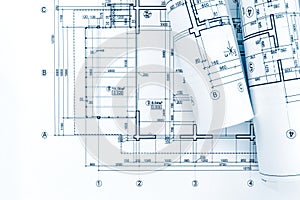 architect workplace with rolls of blueprints and technical drawings