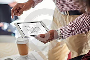 Architector with blueprint on tablet pc at office