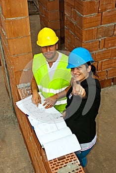 Architects with blueprints pointing up