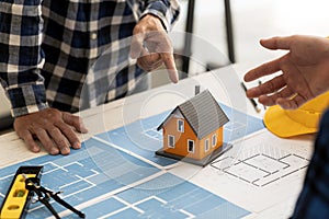 Architects design team is looking at models of small houses, Architect engineers design houses and interiors and draw floor plans