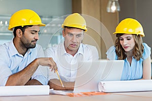 Architects discussing over laptop in conference room