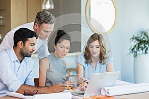 Architects discussing over laptop in conference room