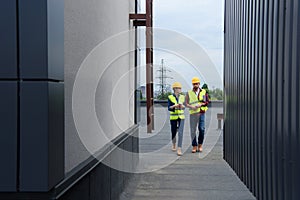 architects in helmets with blueprint and coffee walking