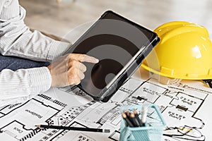Architects are looking at blueprints designed on tablets, designing the house according to the homeowner`s needs. photo