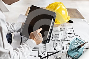 Architects are looking at blueprints designed on tablets, designing the house according to the homeowner`s needs. photo