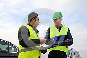 Architects looking at plans, having a discussion at construction site