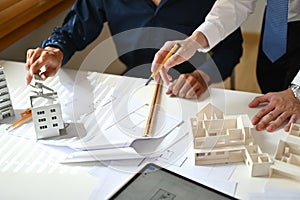 Architects man reviewing blueprints working on sketch of a new construction project at meeting