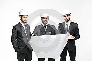 Architects next project. Three indian businessmen architect in the construction helmets standing isolated on white background