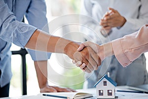 Architects who design buildings and houses shake hands with the owners of the housing project after the house plans are presented