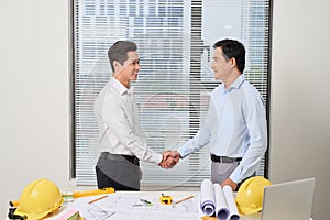 Architects working on plans at office, light effect