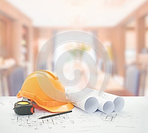 Architectural blueprint with safety helmet and tools over dining room