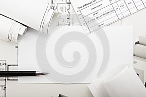 Architectural blueprints and blueprint rolls on white background.