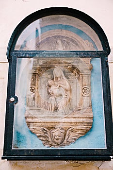 Architectural detail - a bas-relief sculpture of the Virgin Mary with the baby Jesus. Venice, Italy. The bas-relief is