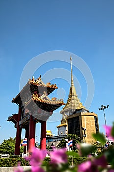 Architectural detail of Buddhist temple, Wat Traimit and Chinatown Gate over blue sky in Bangkok, Thailand