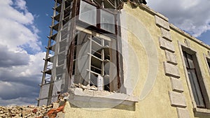 Architectural detail of high frame of monolithic concrete building under construction and old demolished house in front