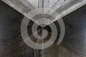 architectural detail of the intersection of two gritty concrete corridors