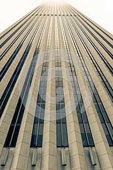 Architectural detail of skyscraper rising into misty sky above,