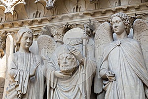 Architectural details of Cathedral Notre Dame de Paris on Cite island in Paris Saint Denis holding his head