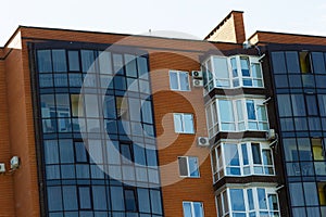 Architectural details of modern high apartment building facade with many windows and balconies