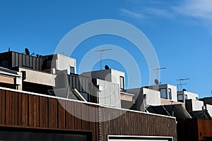 Architectural details showing a row of modern town house apartments on a sunny day and a blue sky.