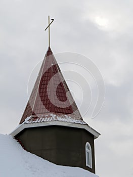 Architectural element of the building of the Church with a cross against the cloudy sky