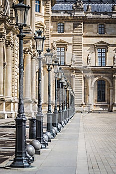 Architectural landscape of the alleys and lamps of the Place des Pyramides of the Louvre Museum in Paris