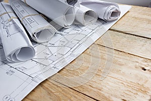 Architectural project, blueprints, blueprint rolls on vintage wooden background. Construction concept. Engineering tools top