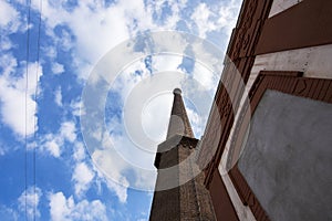 Architectural view of  a  big chimney in a blue sky with white clouds