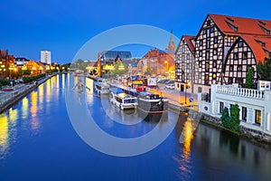 Architecture of Bydgoszcz city with reflection in Brda river at night