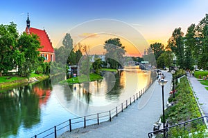 Architecture of Bydgoszcz city with reflection in Brda river at sunset