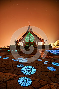 Architecture of Church temple with bodhi tree glowing and fluorescence lotus painting on the floor at Wat Sirindhorn Wararam or