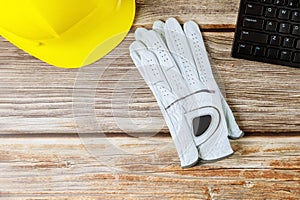 Architecture construction builder office with leather work gloves and safety yellow hardhelmet