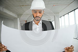 architecture, construction business and building concept - happy smiling indian male architect in helmet.