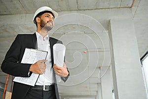 architecture, construction business and building concept - happy smiling indian male architect in helmet.