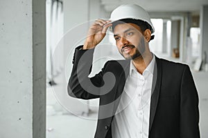 architecture, construction business and building concept - happy smiling indian male architect in helmet.