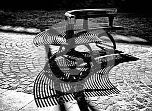 Architecture detail, bench in the city park, bench in city square in black and white, bench shadows , architecture fragment in bla photo