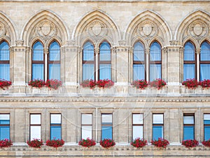 Architecture detail with the front view windows facade of a gothic style building. Rathaus, city or town hall close up