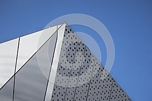 Architecture detail of a modern building with a blue sky on background. Facade design.