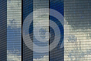 Architecture detail, windows of an office building with reflections of clouds