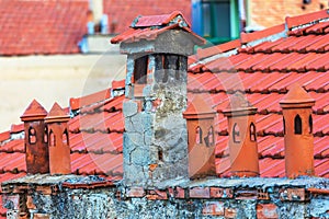 Architecture details of the house with old chimneys and tile roof on the background