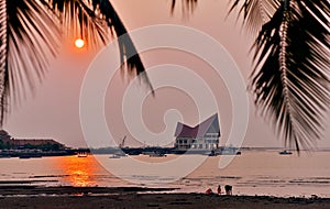 Architecture at dock with sunset sky and palm tree silhouette foreground